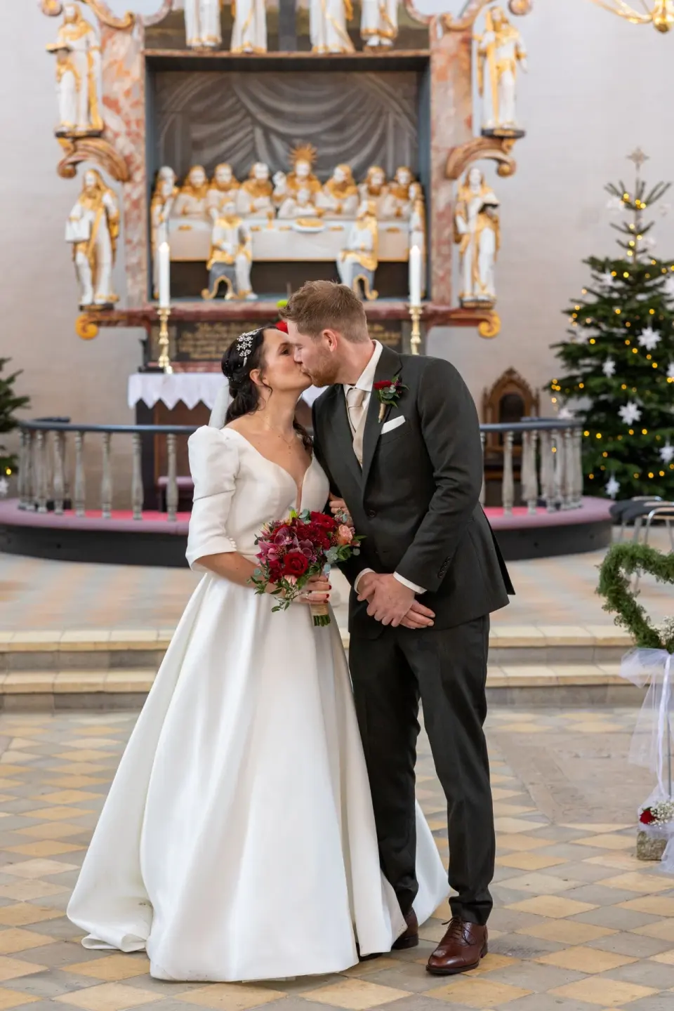 Brudeparret kysser hinanden på kirkens trappe efter vielsen